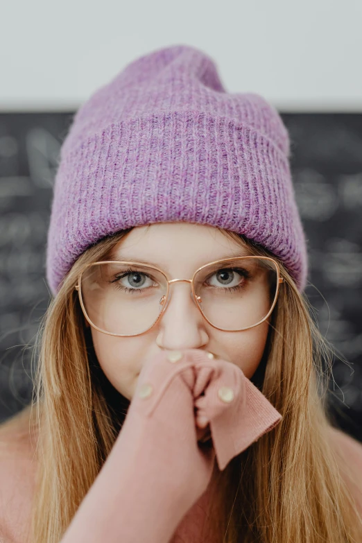 a beautiful blond woman with glasses and a purple hat