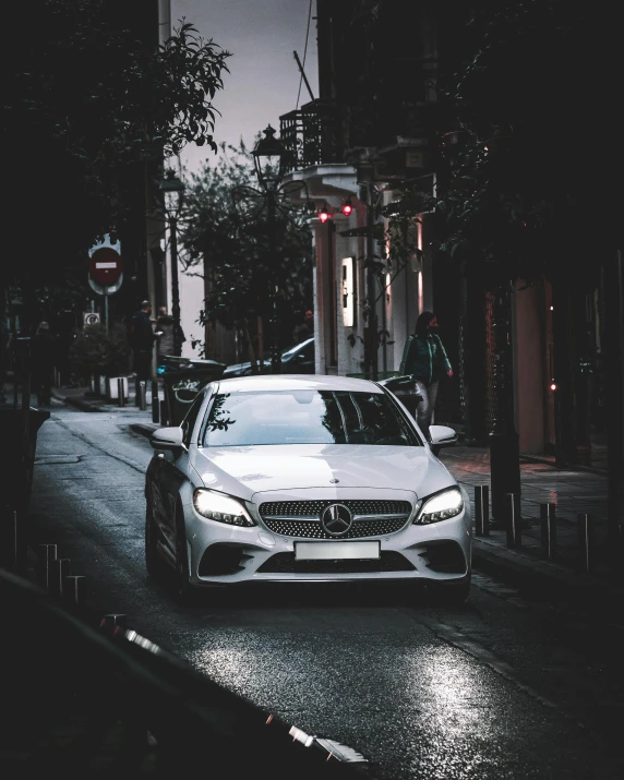 a white car is parked on a city street at night
