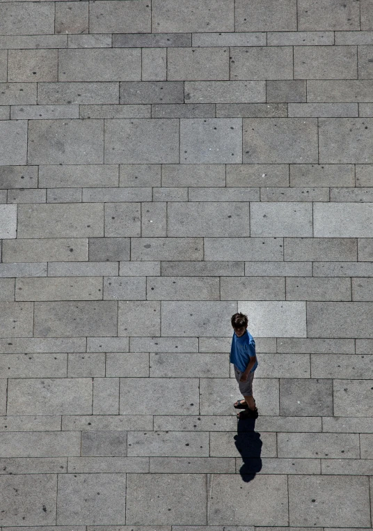 a skateboarder standing in front of a brick wall