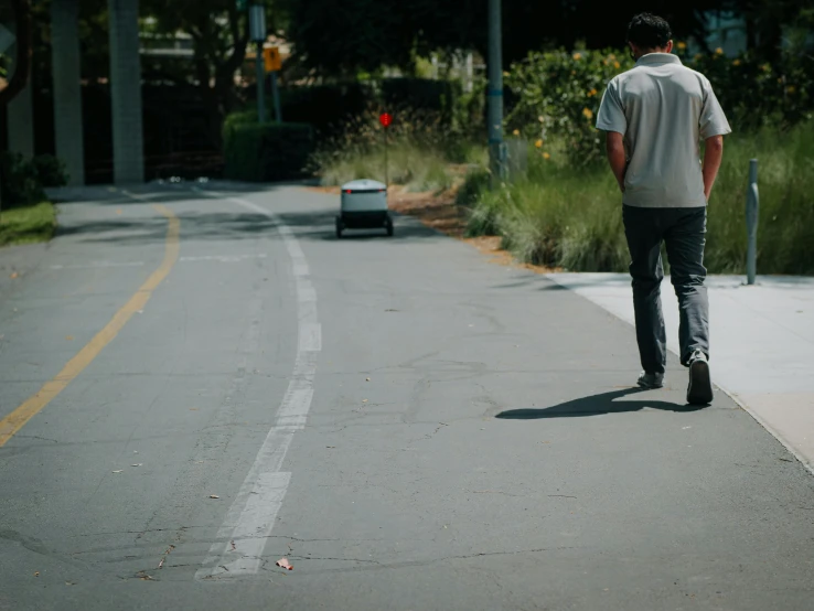 a man walks down the street while looking at a car