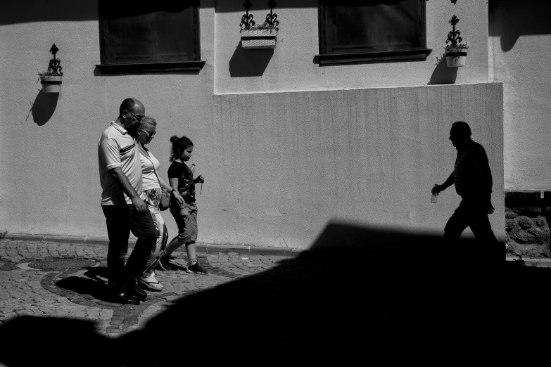 people are walking on the side of a building