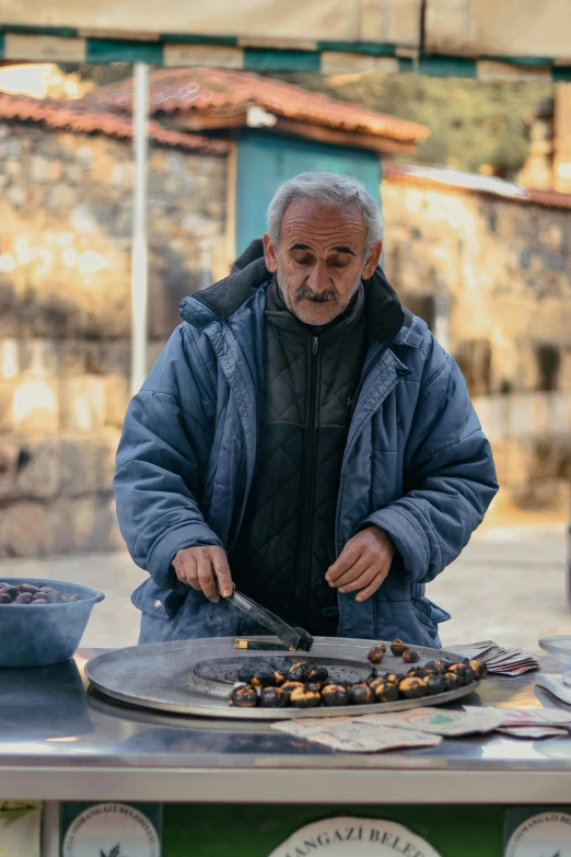 an elderly man preparing food in his village