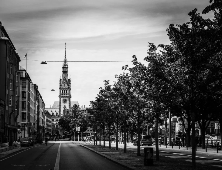 a dark street with trees and buildings along it