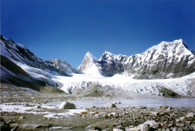 the mountains in the snow and a small body of water