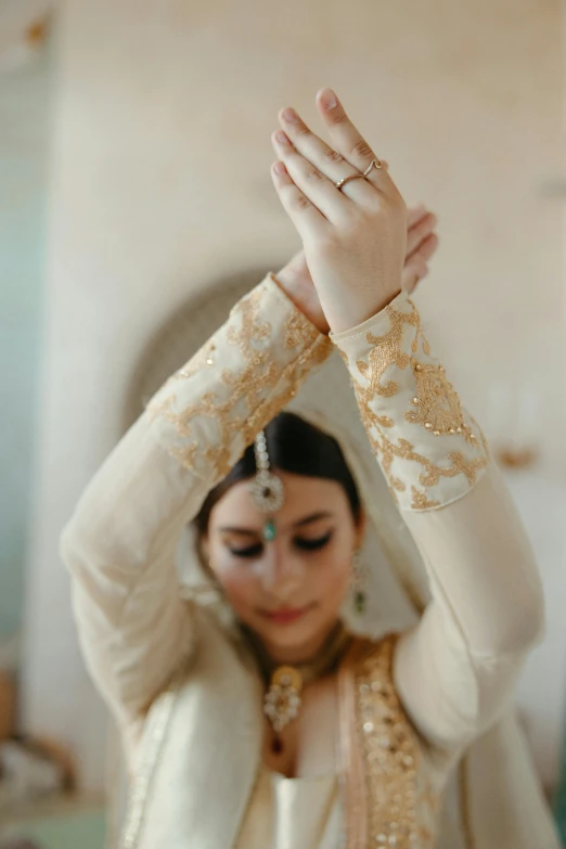 the bride holds her hands up and she is holding her head