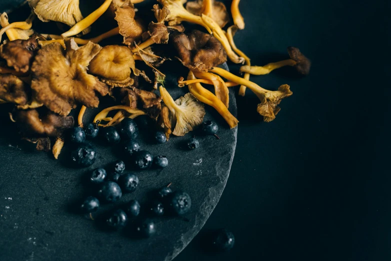 a bunch of fruits sit on a dark plate