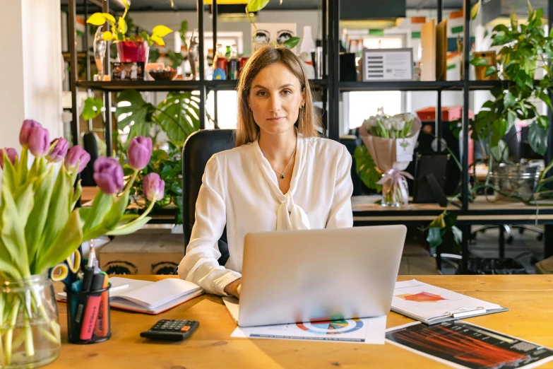 a woman sitting in an office with a laptop