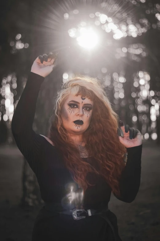 a woman holding up two fingers while wearing makeup