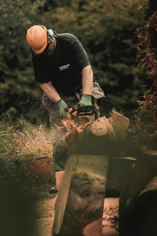 a man with an orange hard hat on  a piece of wood