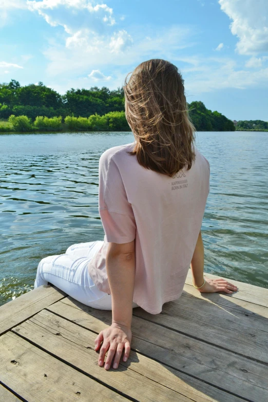 a woman sitting on the end of a dock