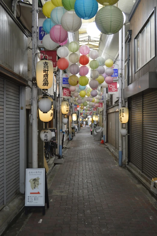 several lanterns hanging from the ceiling near buildings