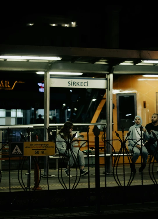 a group of people sitting outside a train