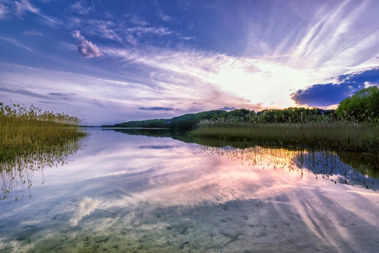 a lake with lots of water under a cloudy blue sky