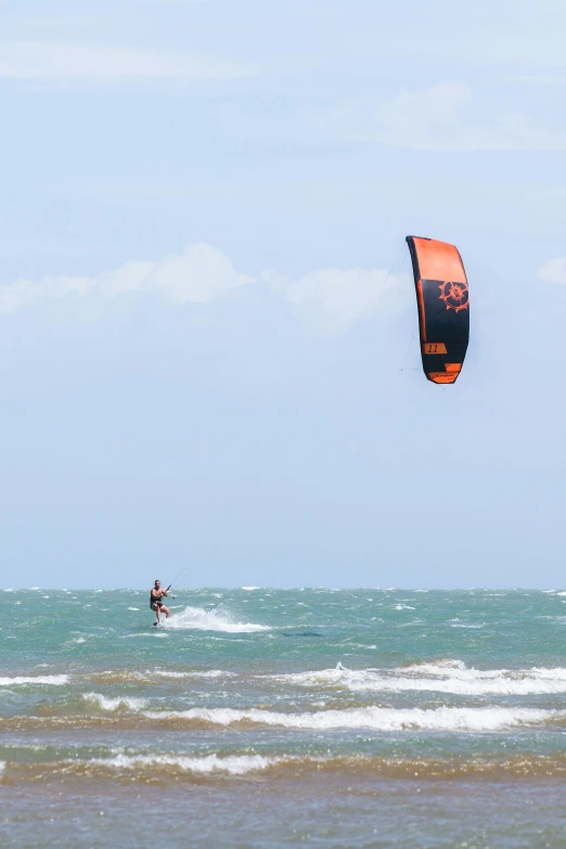 two people with parasails riding in the ocean