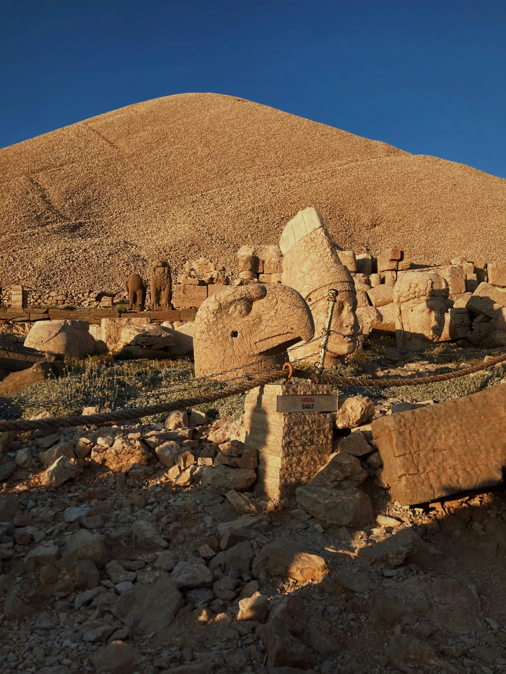 the large building on the side of the hill has many rocks around it