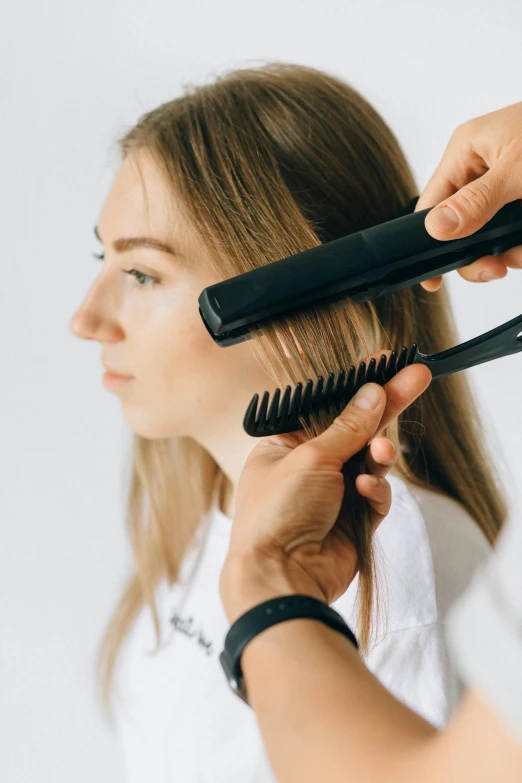 someone  a woman's hair using a hair brush