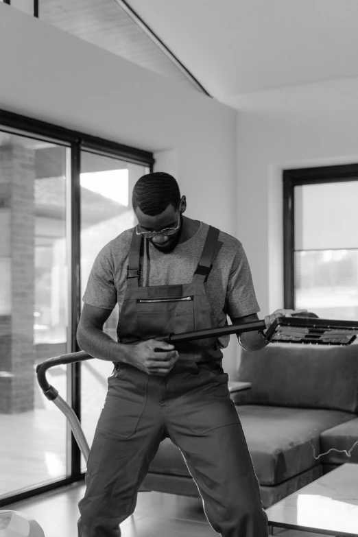 a man in an industrial outfit stands with a hammer