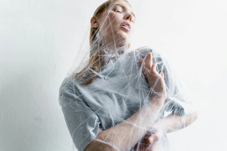 a woman is covered with white fabric over her shoulder