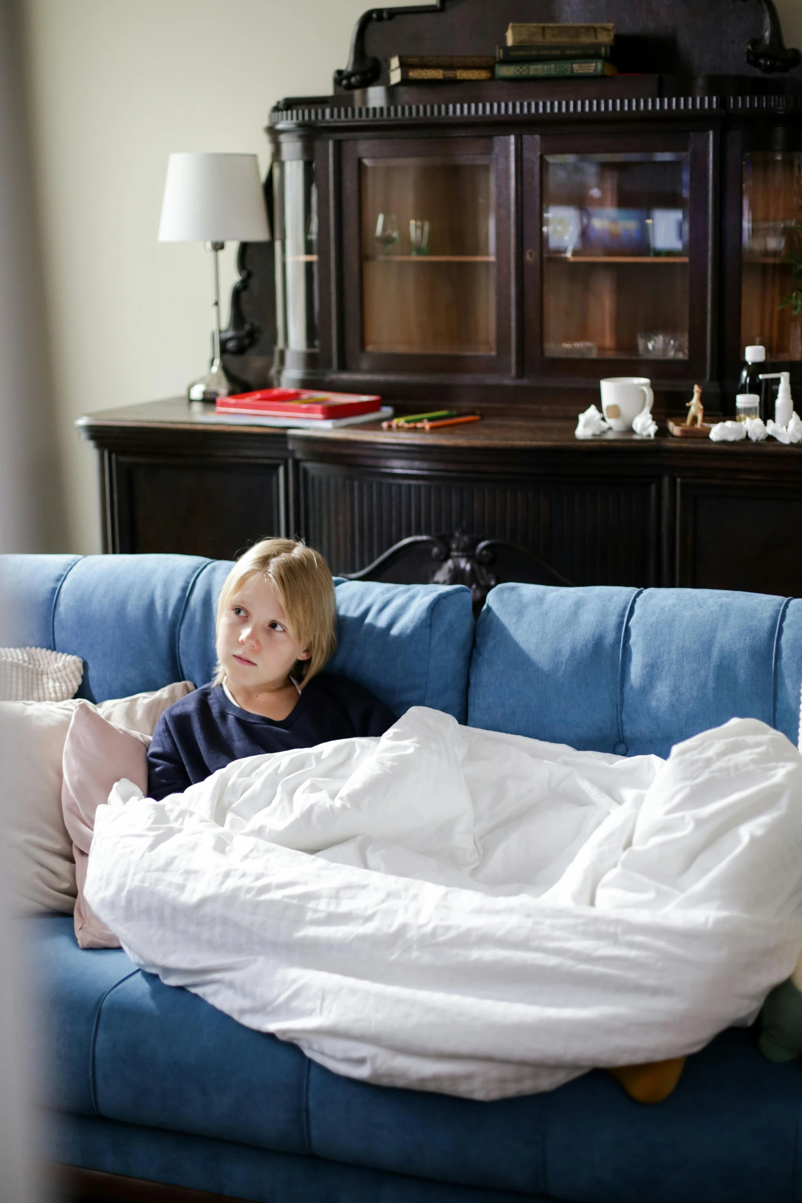 a little boy laying on a blue couch