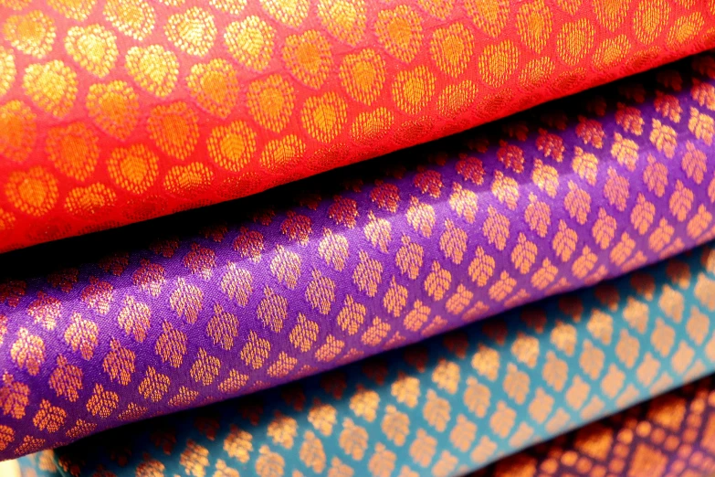 three different colored fabrics sitting side by side