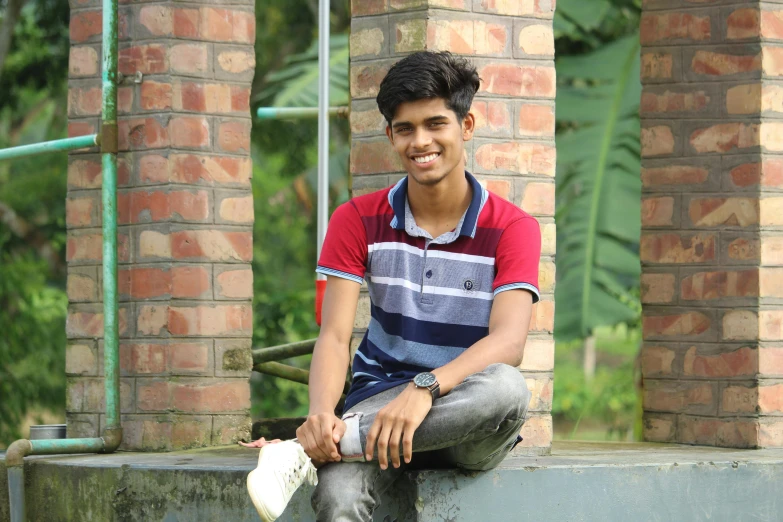 a man sitting on top of cement next to a brick building