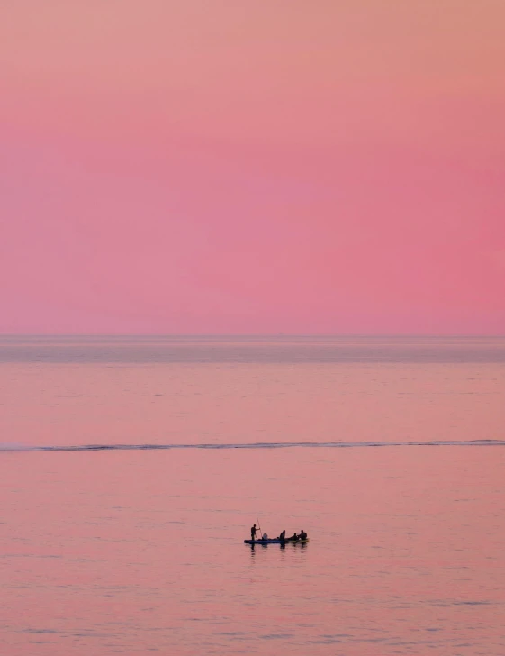 a couple of boats in the ocean at sunset