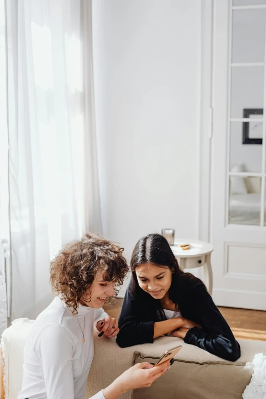 two people are looking at a cell phone