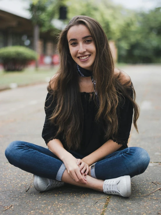 a woman is sitting down while wearing jeans