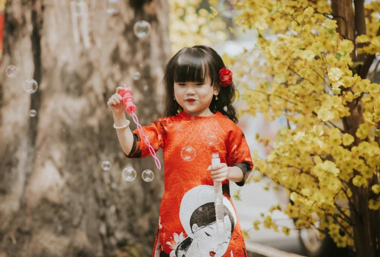  in dress blowing bubbles near tree