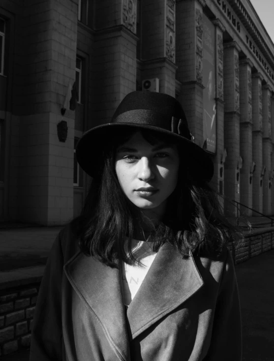 black and white pograph of a woman in an autumn coat, hat, and jacket