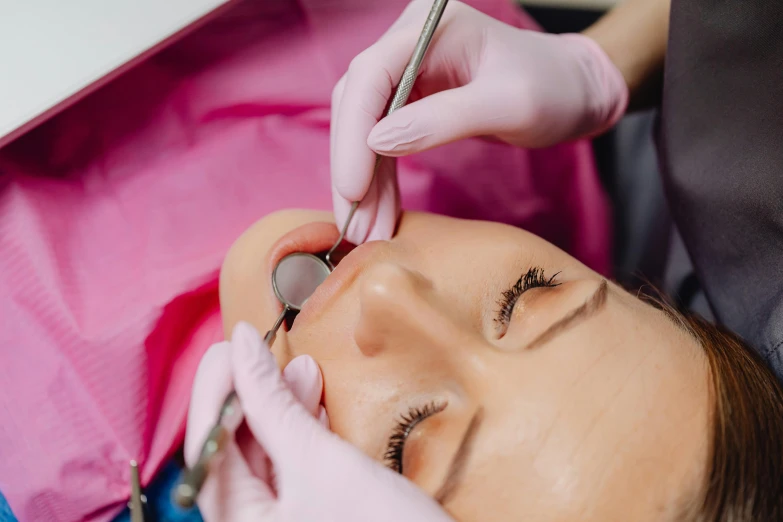a woman getting her eye cut by a dentist