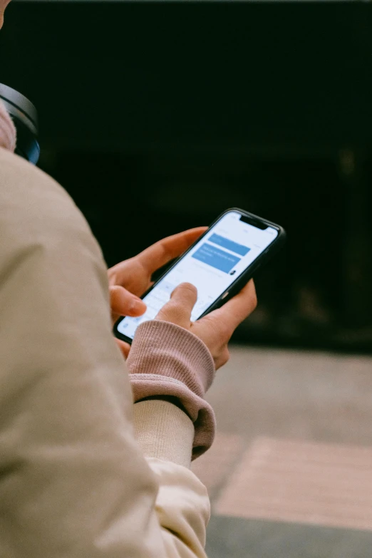 a person sitting down texting on a cell phone