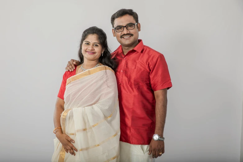 an indian couple posing for the camera on a white background