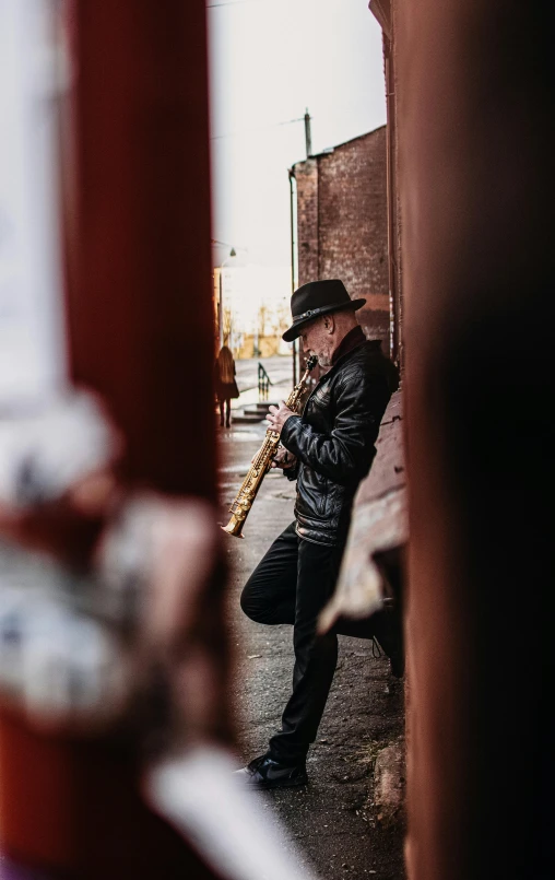 a man is playing his saxophone in the street