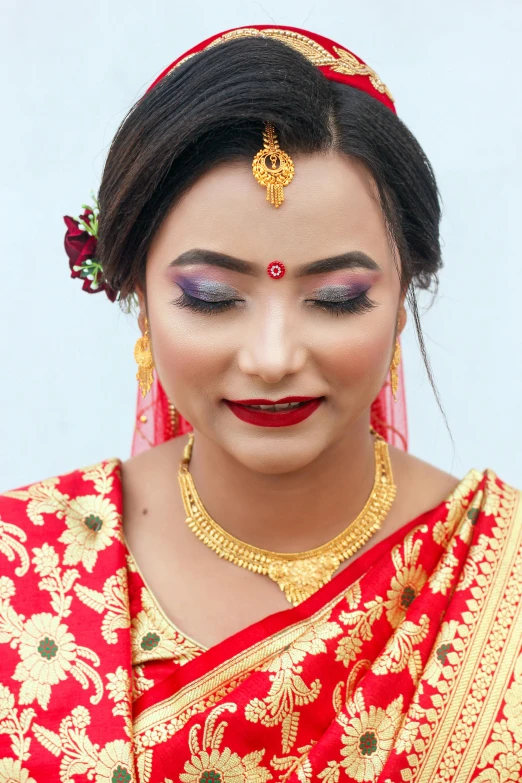 a woman in a red and gold outfit with flowers in her hair