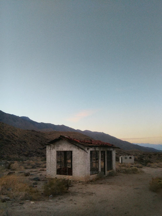 there is a white building and some mountains