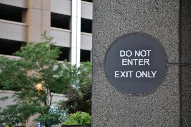 an exit sign has been written on a stone pillar