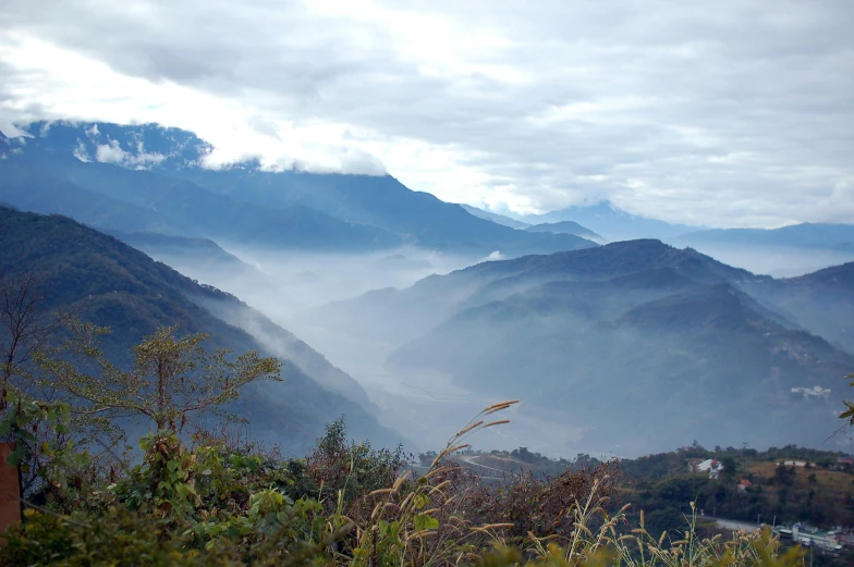 some mountains have fog in them and it is cloudy