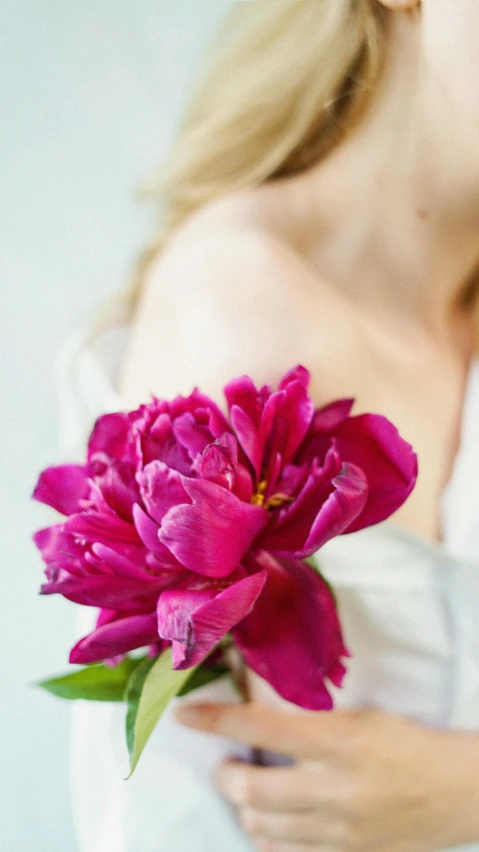 a person in white dress with pink flower