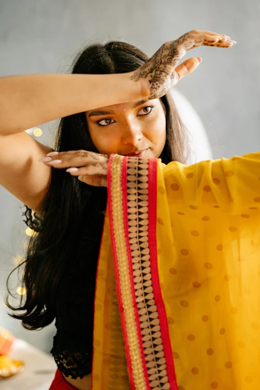 woman in yellow sari holding red and orange tie