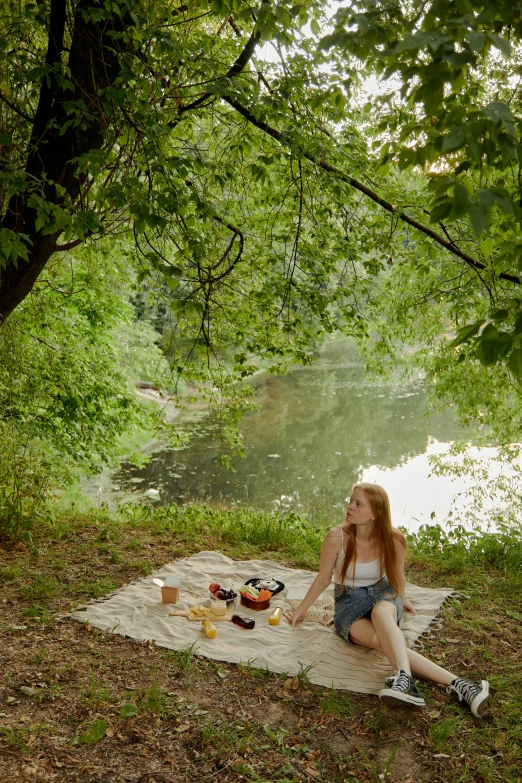 a young lady is on a picnic near a lake