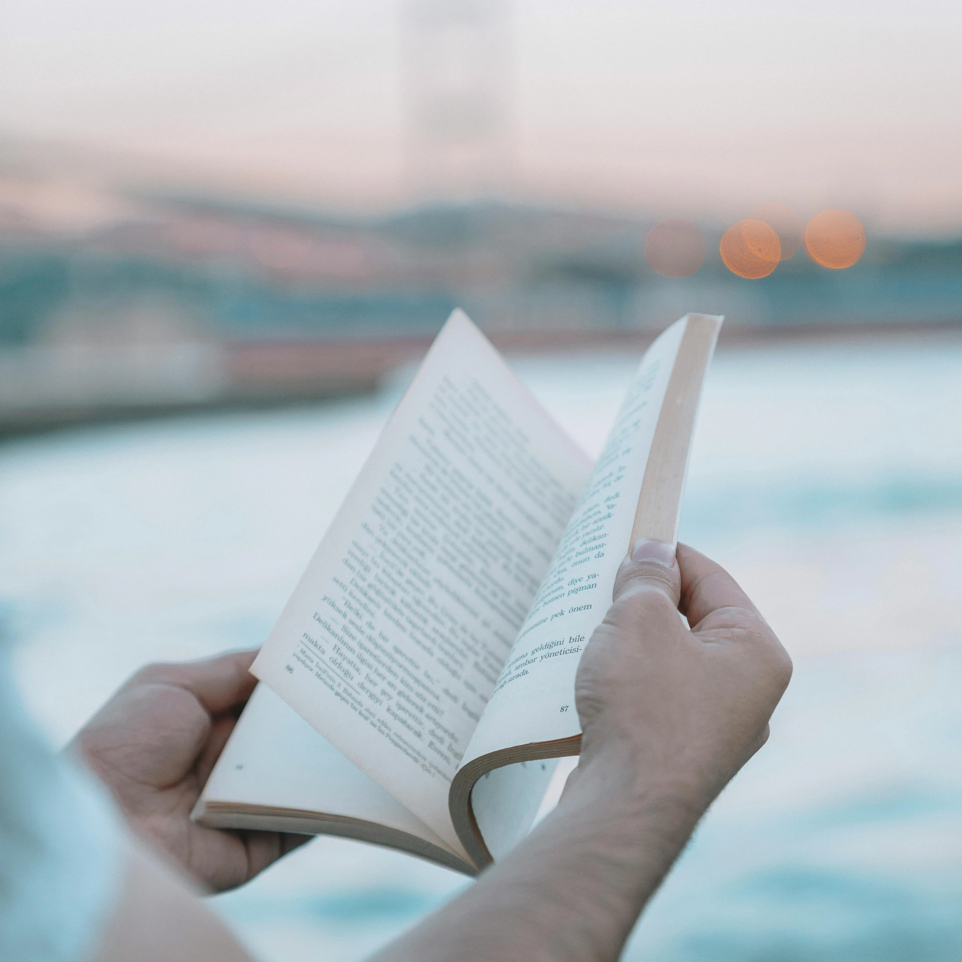 a person holding an open book in their hands