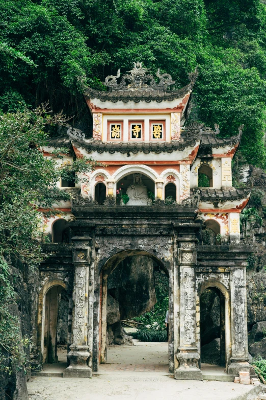 an old structure with some statues and trees around it