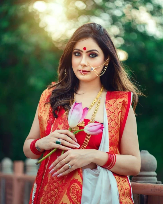 an indian woman wearing an orange saree with flowers
