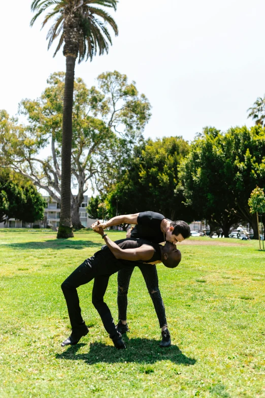 two people are doing a hand stand in the grass