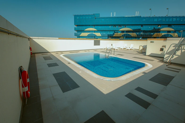 an empty pool sits in an empty rooftop