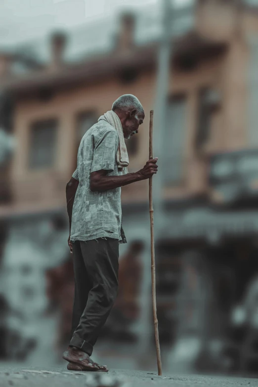 a man carrying wood sticks standing next to a building