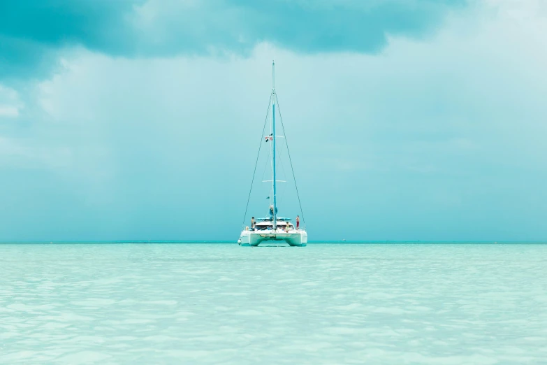 a sailboat floating through the ocean on a clear day