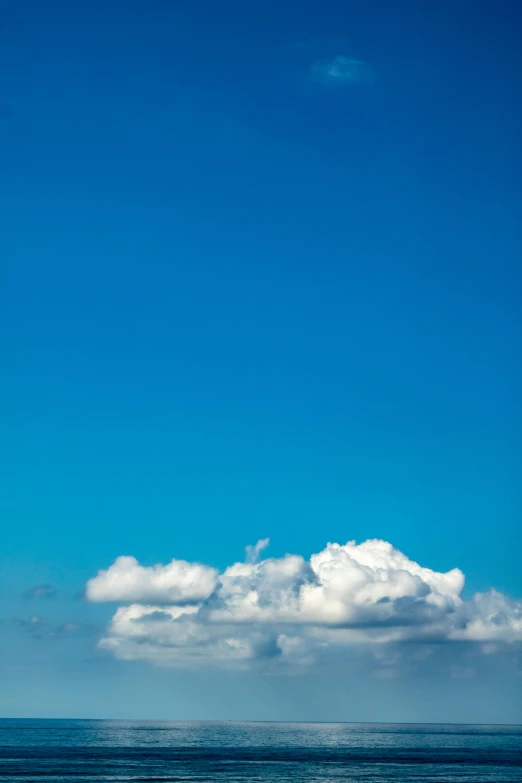 the water is blue and smooth and has some clouds