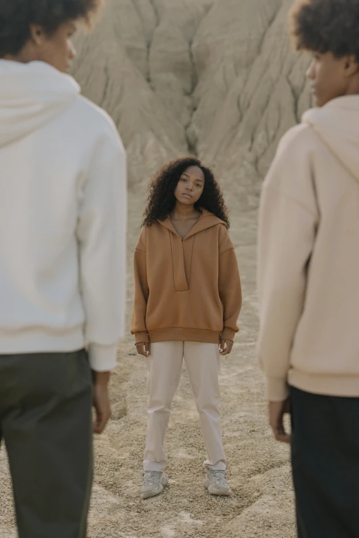 a group of children wearing brown hoodies standing around